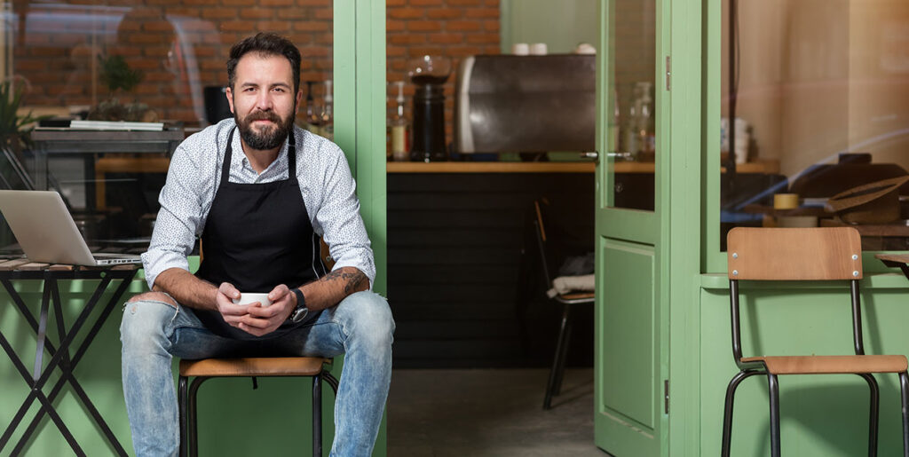business owner sitting in front of shop